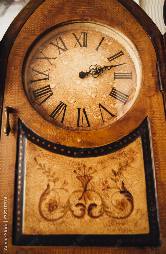 Antique, expensive, wall, brown wooden clock with Roman numerals. Photography, concept.