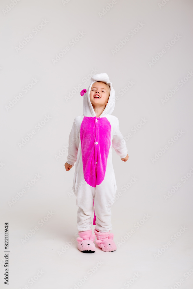 little blonde girl in kigurumi on white background, space for text.modern fashion -children girl posing on a white background in kigurumi pajamas, bunny costume little blonde girl in kigurumi on white background, space for text.modern fashion -children girl posing on a white background in kigurumi pajamas, bunny costume