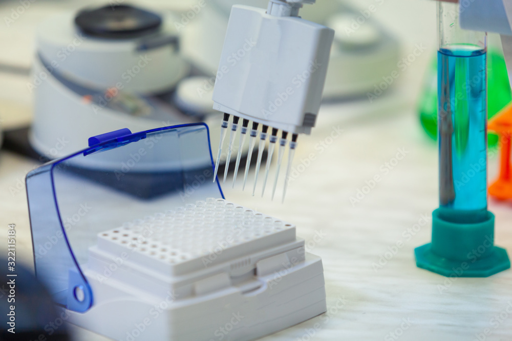 Laboratory worker puts samples into a tray making analysis for immunity viruses in a medical laboratory. Laboratory worker puts samples into a tray making analysis for immunity viruses in a medical laboratory.