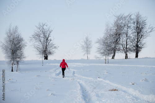 Woman running on snow in winter mountains. Sport, fitness inspiration and motivation. 