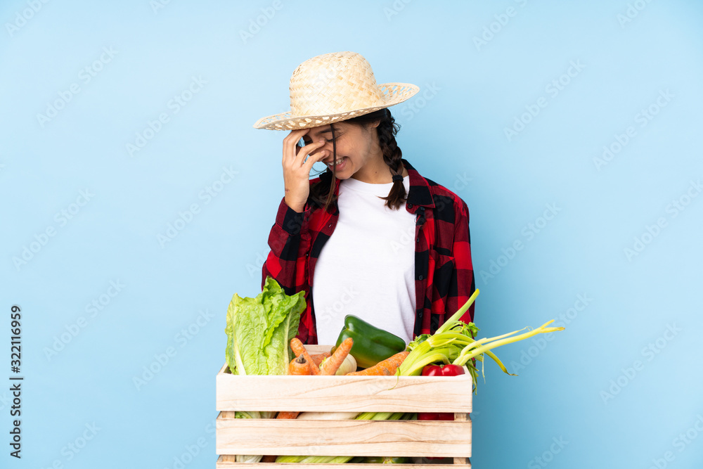 Young farmer Woman holding fresh vegetables in a wooden basket laughing