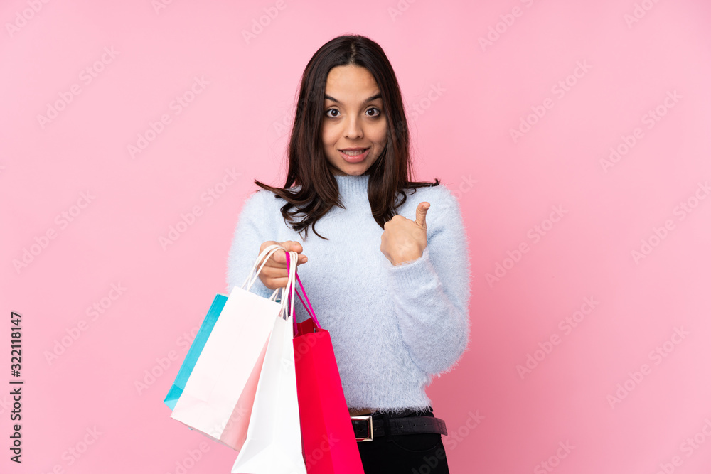Young woman with shopping bag over isolated pink background with surprise facial expression Young woman with shopping bag over isolated pink background with surprise facial expression