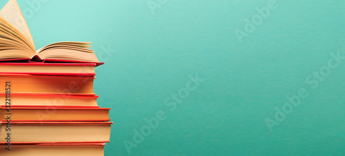 Opened Book on a pile of old books on blue background