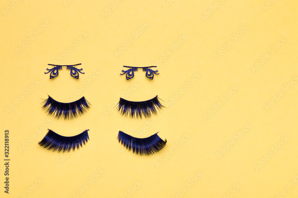 three pairs of different false eyelashes on a yellow background copy space top view, fluffy black eyelashes, butterfly-shaped eyelashes three pairs of different false eyelashes on a yellow background copy space top view, fluffy black eyelashes, butterfly-shaped eyelashes