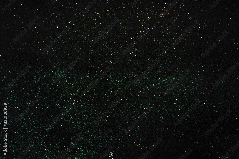Texture of a dark surface with fine light crumbs. Dark background with sparkles