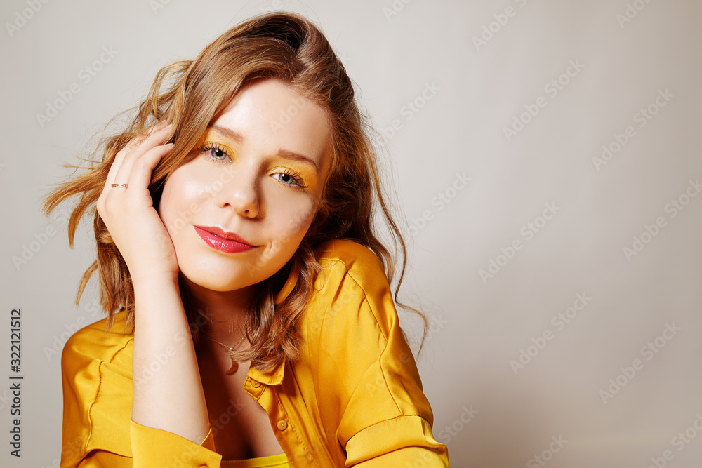 Beautiful portrait of a young girl with beautiful natural makeup, short haircut, large beautiful earrings. Girl all in yellow Beautiful portrait of a young girl with beautiful natural makeup, short haircut, large beautiful earrings. Girl all in yellow