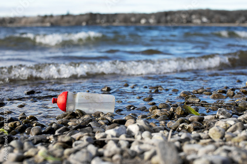disposable society, discarded plastic drinking bottle floating in lake Ammersee Bavaria