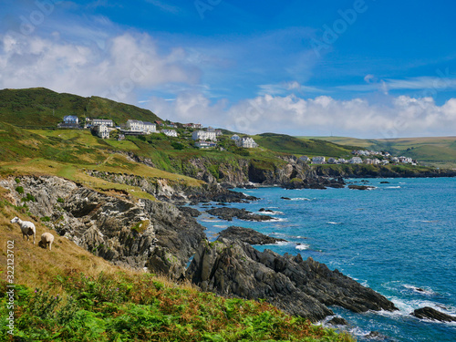 The seaside resort town of Woolacombe on the rugged north Devon coast. The foreground shows the steeply inclined slate strata of the Morte Slates Formation. Taken from the South West coast path.