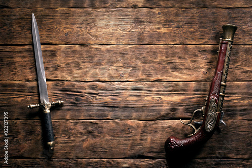 Bild auf Leinwand Ancient weapon on brown wooden table background with copy space