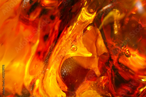 Beautiful bright red-yellow amber background. Luxury texture. Sun stone with bubble. Petrified resin of ancient fossil trees. Material for jewelers. Natural mineral. Digging. amber. Overflow colors photo