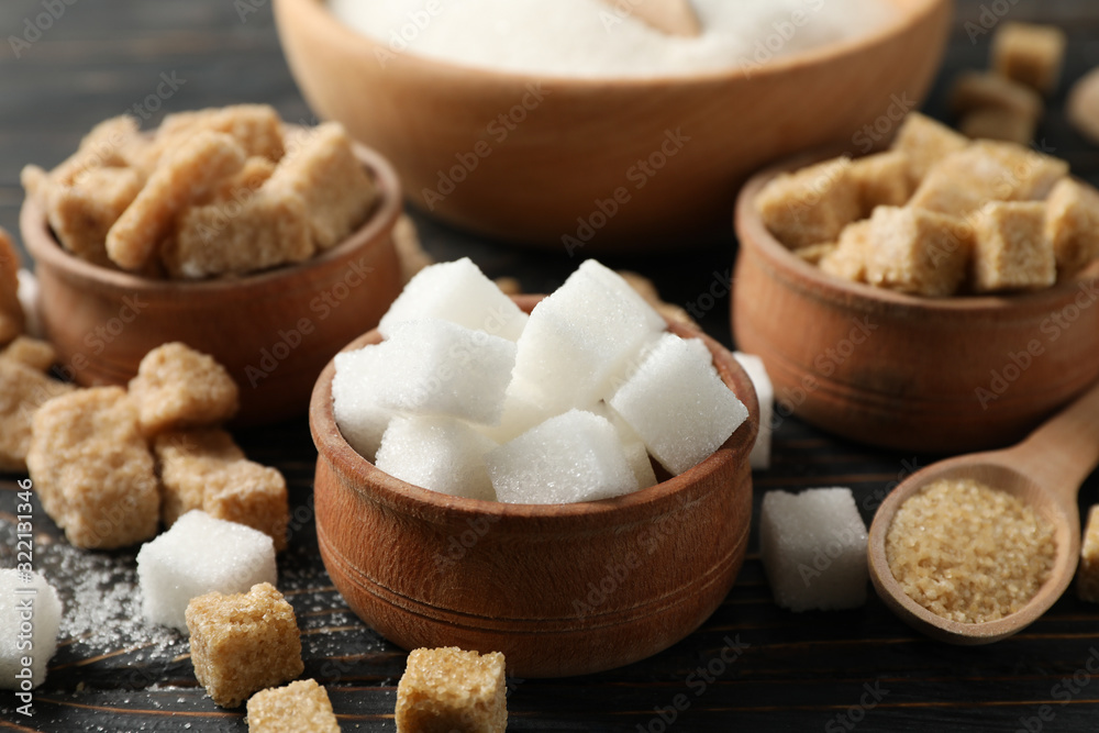 Bowls with different sugar on wooden background, close up Bowls with different sugar on wooden background, close up