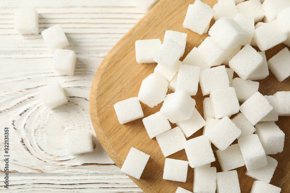 Board with sugar cubes on wooden background, top view Board with sugar cubes on wooden background, top view