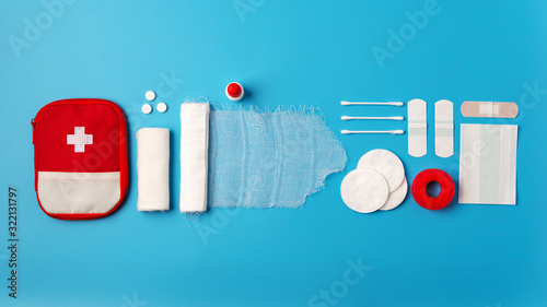 Canvas-taulu Contents of the first aid kit on a blue background, bandages, cotton wool, pills