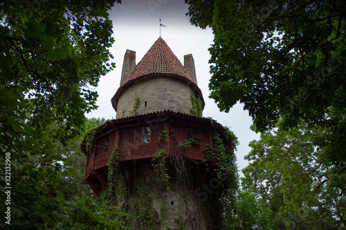 Old Castle Citadel Tower with red roof behind the green trees. Kiiu Vassal Stronghold, or the Kiiu Tower. photo