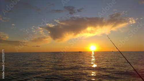 Sea fishing in the evening. Fishing rod and sunset. Summer.