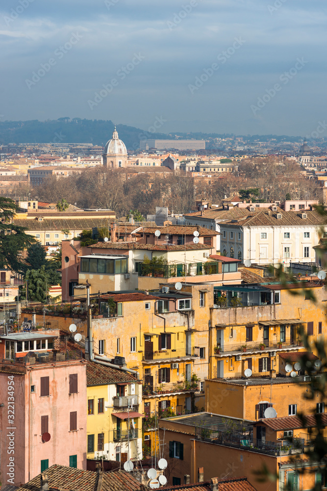 Views across Rome city with colourful old apartments in foreground, seen from Gianicolo or Janiculum Hill, Trastevere, Rome, Italy.