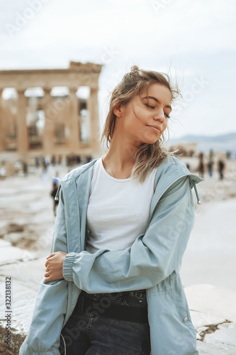 A beautiful city tourist woman explores the ancient Partenon temple of the Acropolis of Athens, Greece