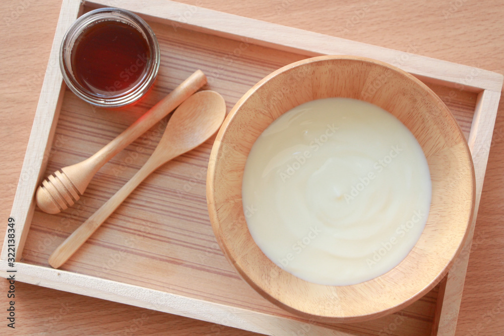 Top view of honey and yogurt in wooden bowl. Top view of honey and yogurt in wooden bowl.