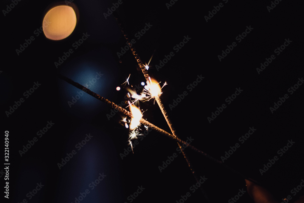 Glittering burning sparkler, abstract blur background Glittering burning sparkler, abstract blur background