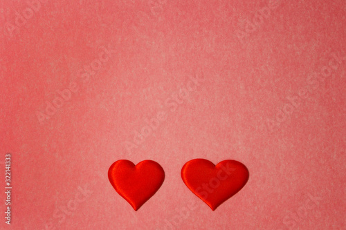 Two red hearts on a red color cardboard background. Copy space, Valentines Day concept