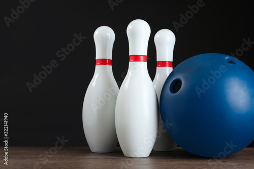 Blue bowling ball and pins on wooden table