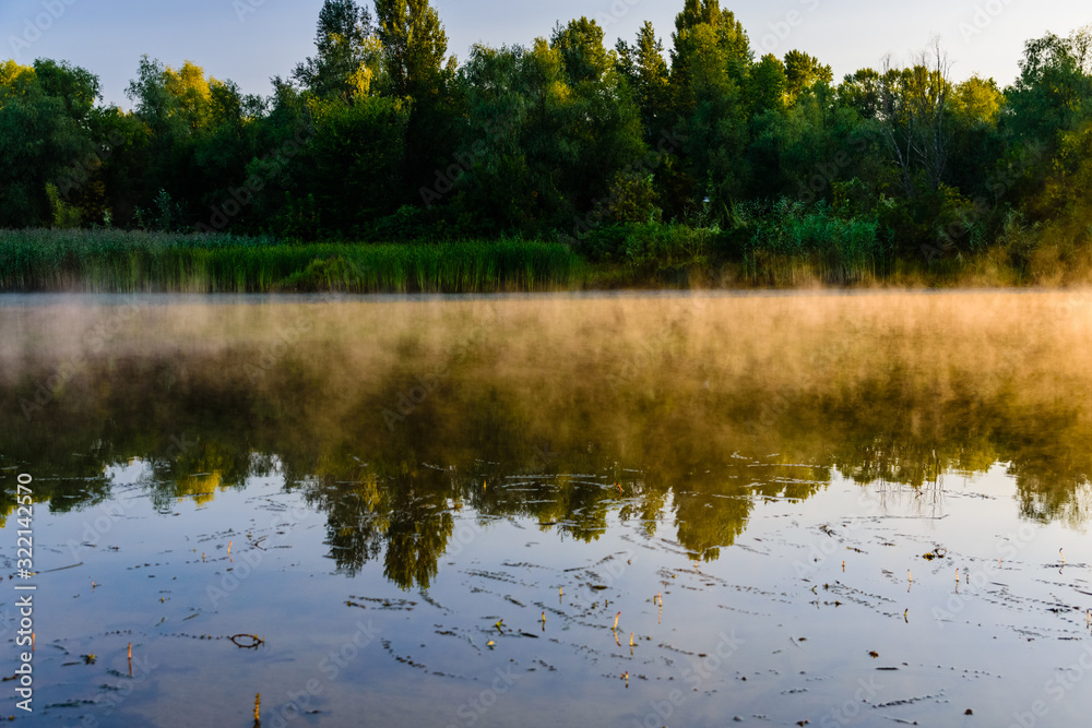 Obraz premium Fog above the water surface. Sunrise at river
