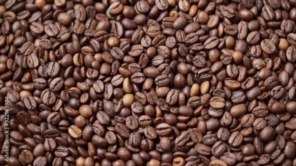 Dark roasted coffee beans move in a circle. Top down view. Dark roasted coffee beans move in a circle. Top down view.