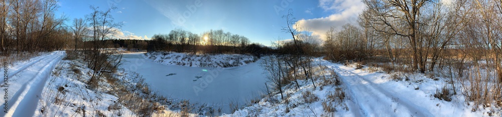Panoramic view with winter river and snow forest. Beautiful winter landscape