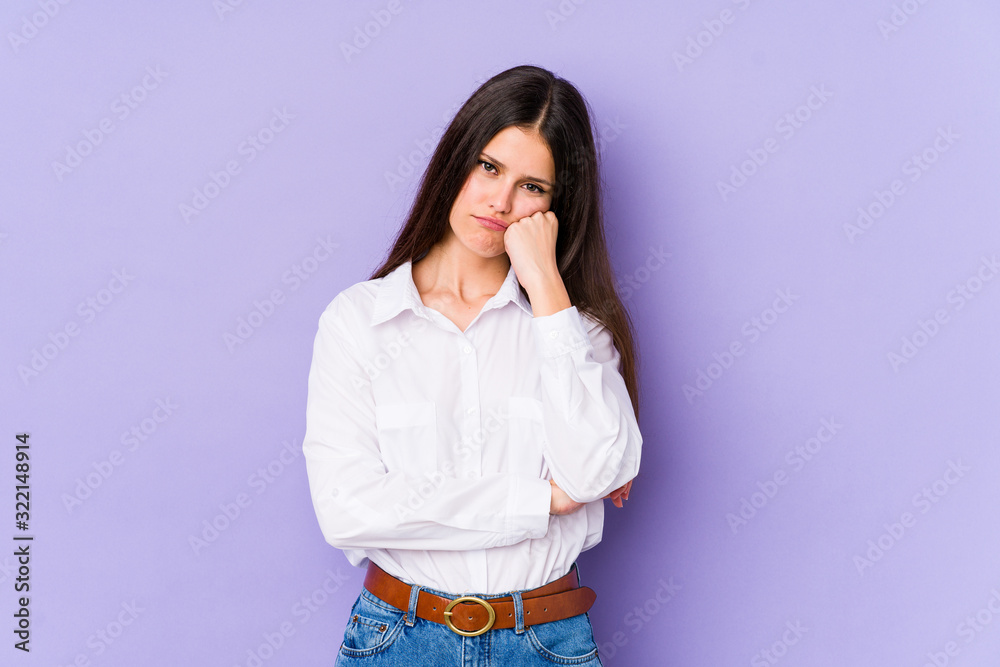 Young caucasian woman isolated on purple background who feels sad and pensive, looking at copy space. Young caucasian woman isolated on purple background who feels sad and pensive, looking at copy space.