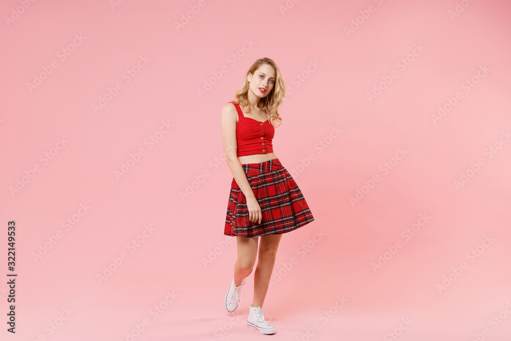 Beautiful young blonde woman girl in red sexy clothes posing isolated on pastel pink wall background studio portrait. People sincere emotions lifestyle concept. Mock up copy space. Looking camera. Beautiful young blonde woman girl in red sexy clothes posing isolated on pastel pink wall background studio portrait. People sincere emotions lifestyle concept. Mock up copy space. Looking camera.