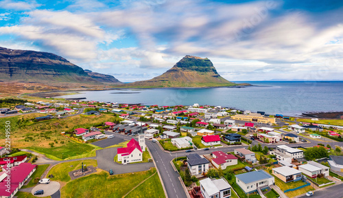 View from flying drone. Splendid morning cityscape of Grundarfjordur town with Kirkjufell Mountain on background. Aerial view of Grundarfjordur Church, Iceland, Europe.