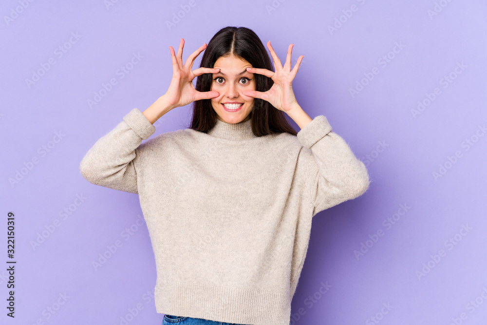 Young caucasian woman isolated on purple background keeping eyes opened to find a success opportunity. Young caucasian woman isolated on purple background keeping eyes opened to find a success opportunity.