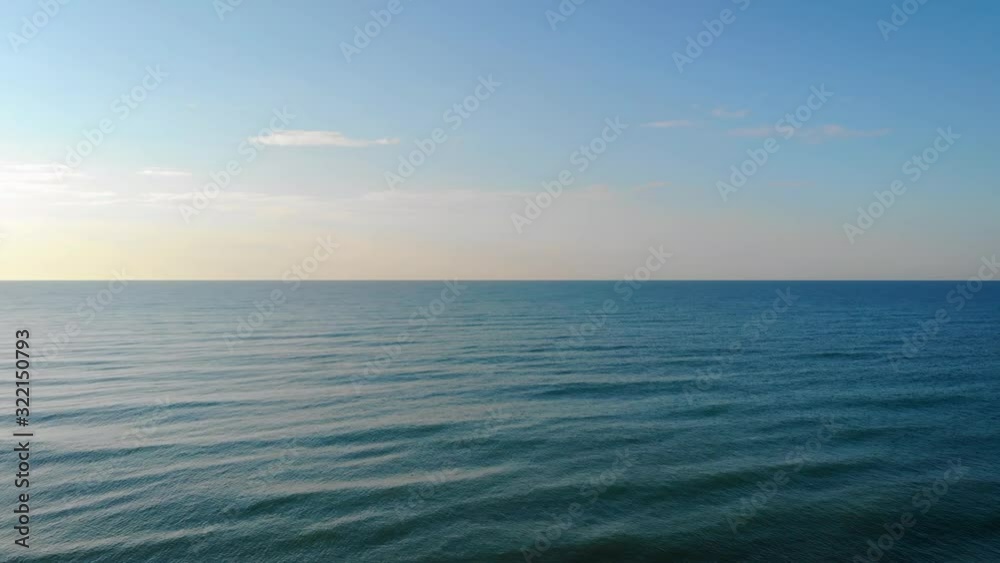 AERIAL: Fly into open waters from the beach. Waves breaking. Sunset vibes. Caorle, Italy AERIAL: Fly into open waters from the beach. Waves breaking. Sunset vibes. Caorle, Italy