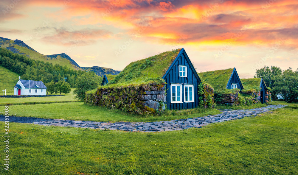 Obraz premium Typical view of turf-top houses in Icelandic countryside. Dramatic summer sunrise in Skogar village, south Iceland, Europe. Traveling concept background.