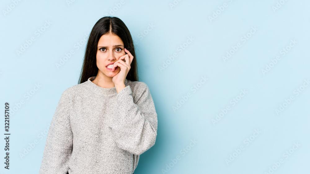 Young caucasian woman isolated on blue background biting fingernails, nervous and very anxious. Young caucasian woman isolated on blue background biting fingernails, nervous and very anxious.