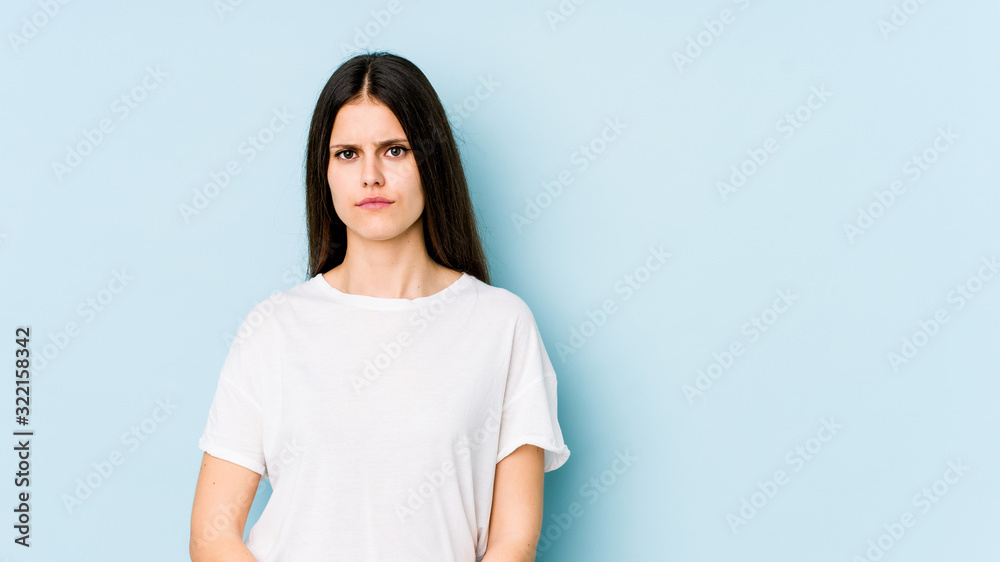 Young caucasian woman isolated on blue background sad, serious face, feeling miserable and displeased. Young caucasian woman isolated on blue background sad, serious face, feeling miserable and displeased.