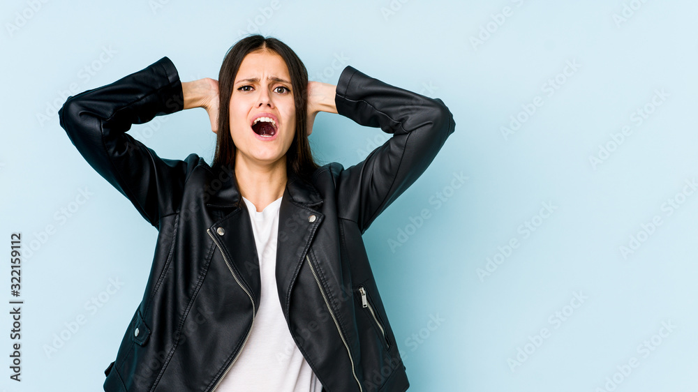 Young caucasian woman isolated on blue background screaming with rage. Young caucasian woman isolated on blue background screaming with rage.