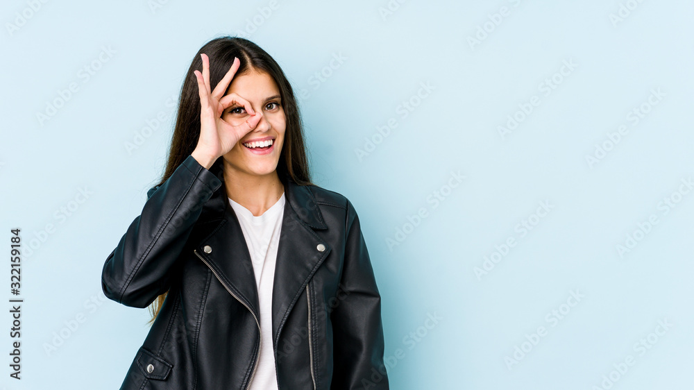 Young caucasian woman isolated on blue background excited keeping ok gesture on eye. Young caucasian woman isolated on blue background excited keeping ok gesture on eye.