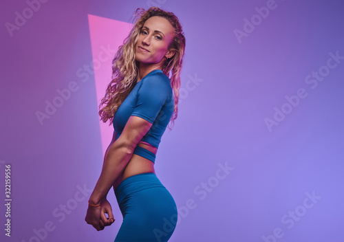 Attractive woman is showing her curvy places at the neon photo studio.