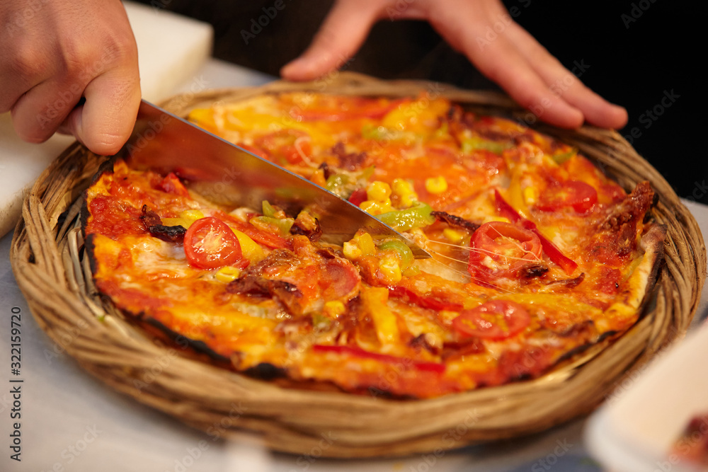 Chef cuts freshly prepared pizza slices Chef cuts freshly prepared pizza slices