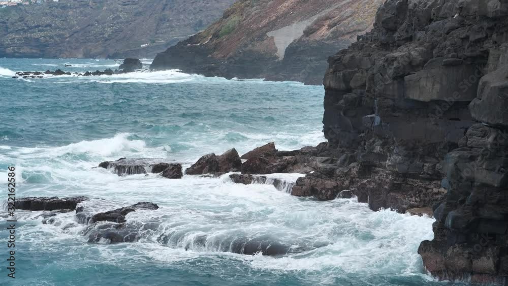 Tilt view of breaking waves and rocky coast of Tenerife island, Canary islands, Spain Tilt view of breaking waves and rocky coast of Tenerife island, Canary islands, Spain