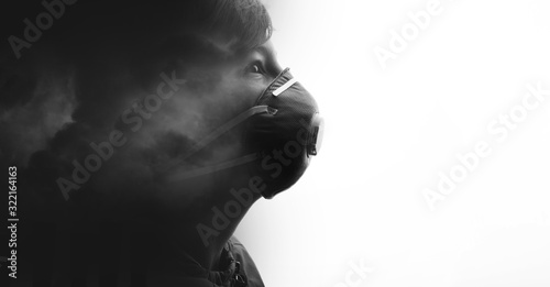 Double exposure of male face and polluting air. Young boy in protective respirator. Child wearing medical mask. Free space for text.