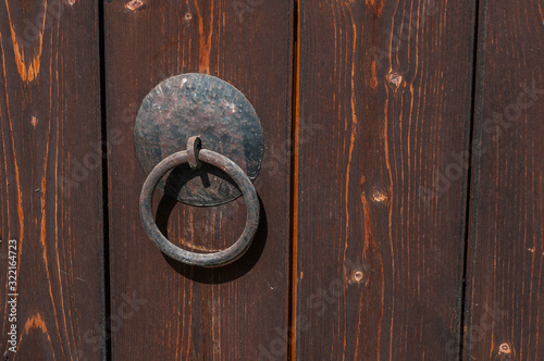 Obraz na plátně Old iron ring on brown wooden boards door