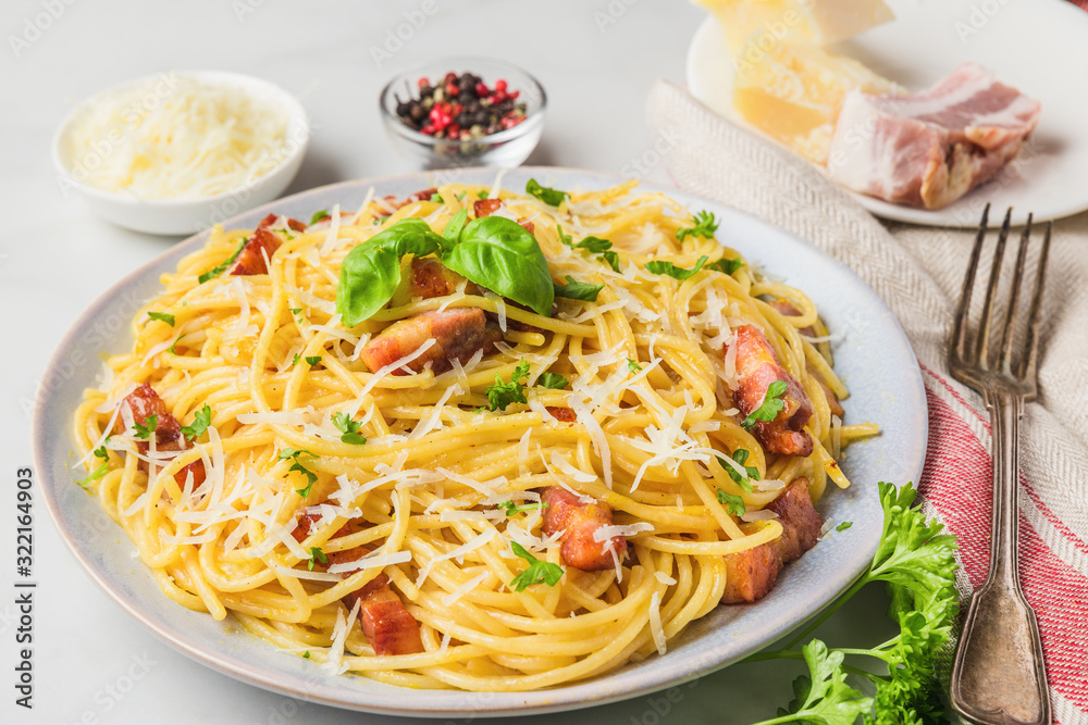 Classic homemade italian pasta carbonara with bacon, eggs, parmesan cheese and parsley in a plate with fork