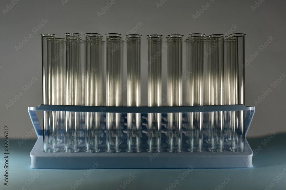 The tray with test tubes in the shade is partially illuminated by a horizontal beam. The tray with test tubes in the shade is partially illuminated by a horizontal beam.