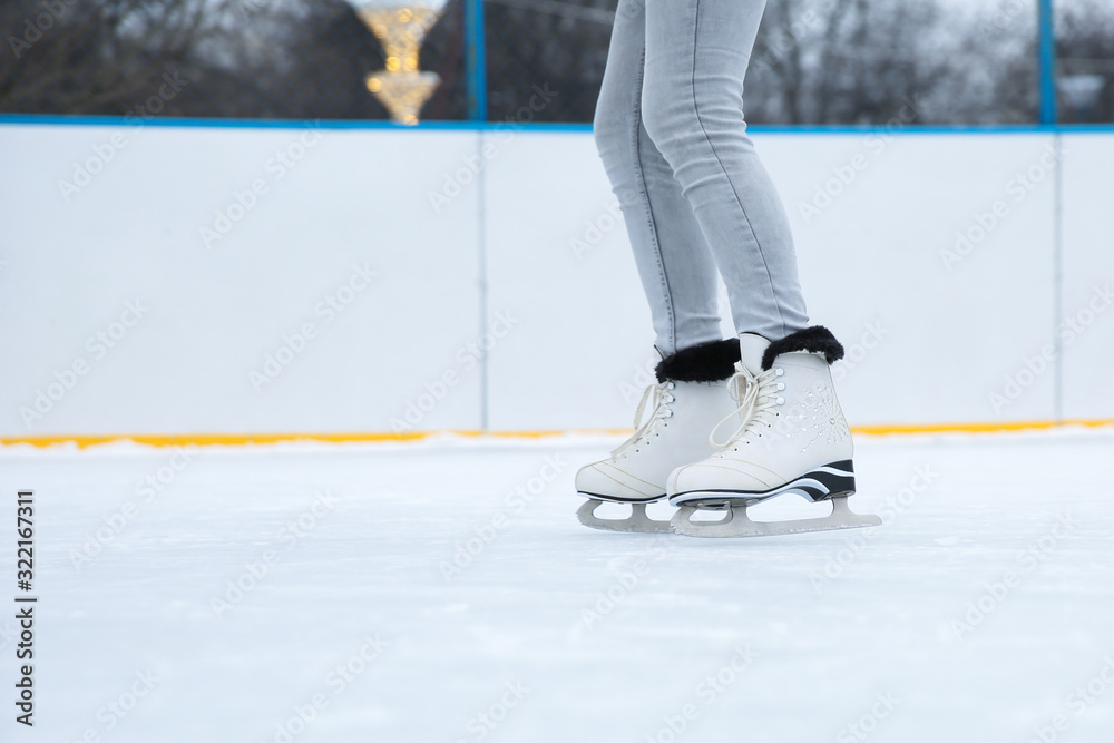 ice skating on the rink close up. white figure skates on woman's legs ice skating on the rink close up. white figure skates on woman's legs