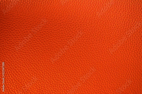 Leather texture close up. Orange fashionable background, top view. Stylish coral wallpaper with rough surface. © ethno4ka