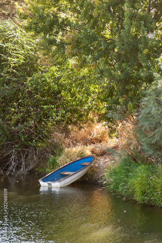 A small rowboat sits on a shore near a small opening