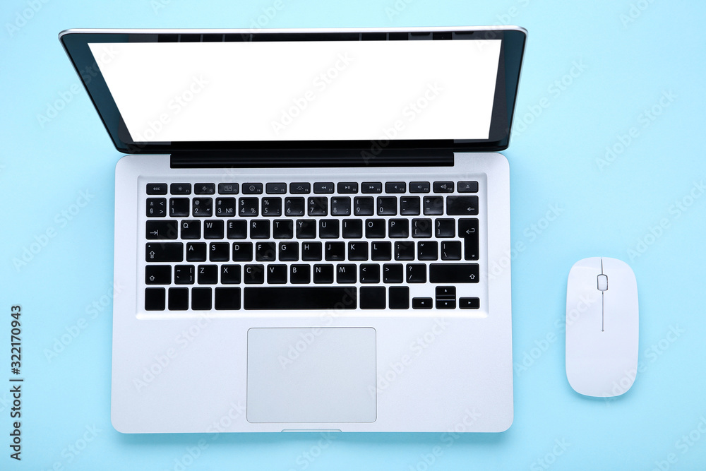 Laptop computer with mouse on blue background Laptop computer with mouse on blue background