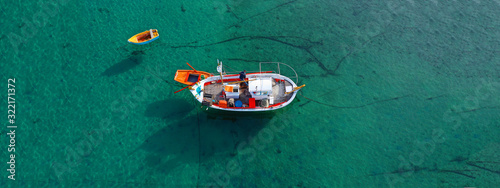 Aerial drone ultra wide photo of traditional fishing boat docked in old port of Mykonos island, Cyclades, Greece